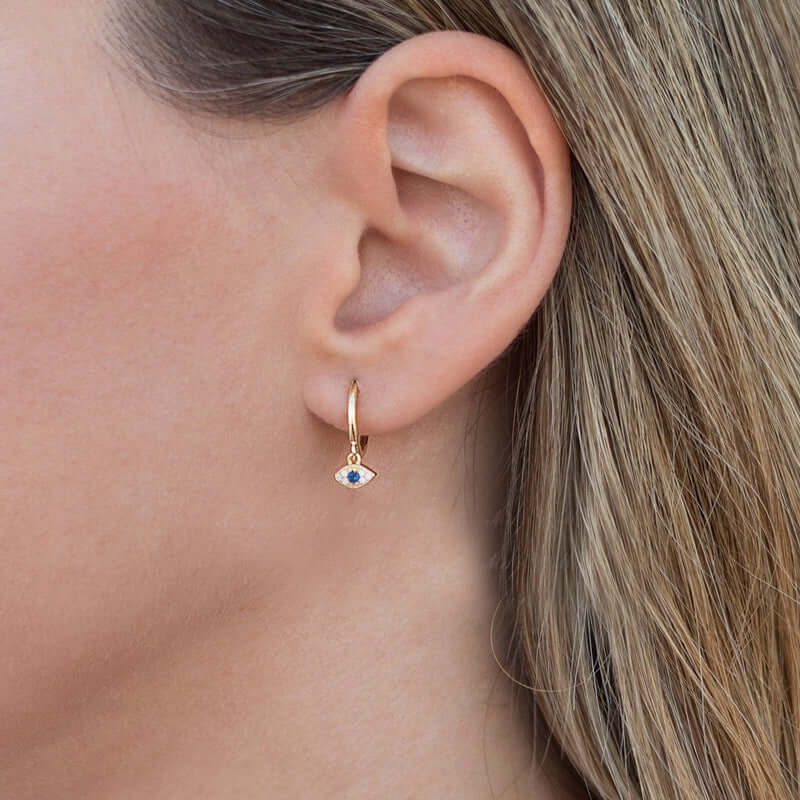 Small gold hoop earrings with blue evil eye pendant on model – Links & Loops Jewellery
